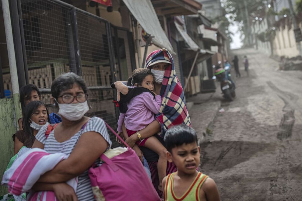PHOTO: Residents fleeing Taal Volcano's eruption wait for a ride on the side of a highway, Jan. 13, 2020, in Lemery, Philippines.