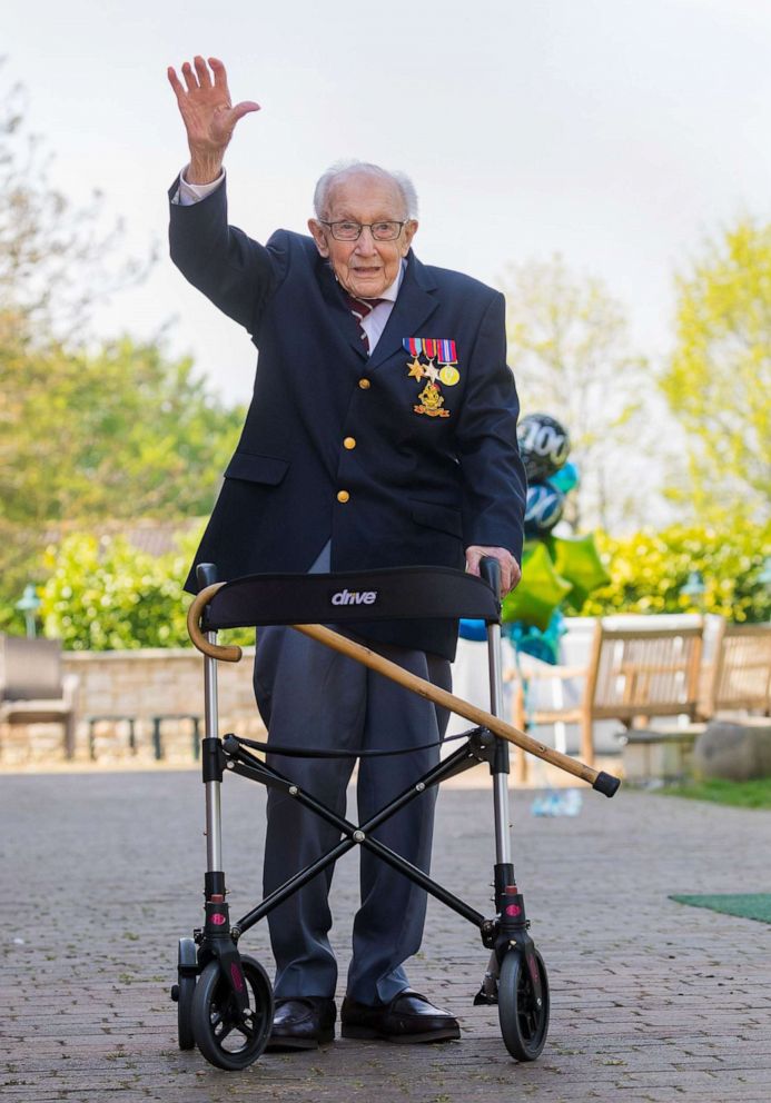 PHOTO: 99-year-old British veteran Captain Tom Moore waves after completing the 100th lap of his back garden in Marston Moretaine, Bedfordshire, Britain, April 16, 2020.