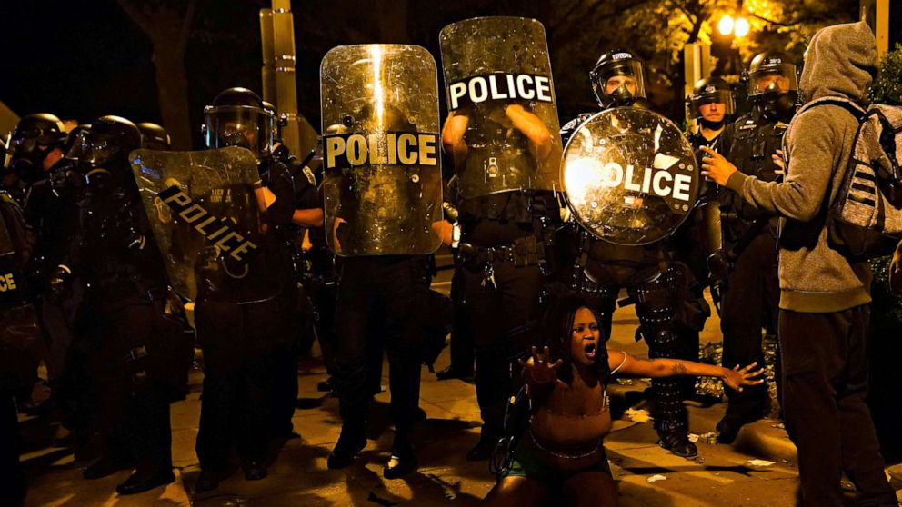 PHOTO: Law enforcement officers look on as a person protests near the White House against the death in Minneapolis police custody of George Floyd in Washington, May 30, 2020.