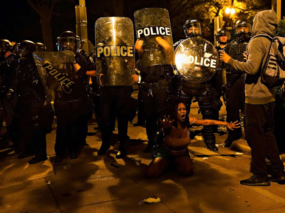 PHOTO: Law enforcement officers look on as a person protests near the White House against the death in Minneapolis police custody of George Floyd in Washington, May 30, 2020.