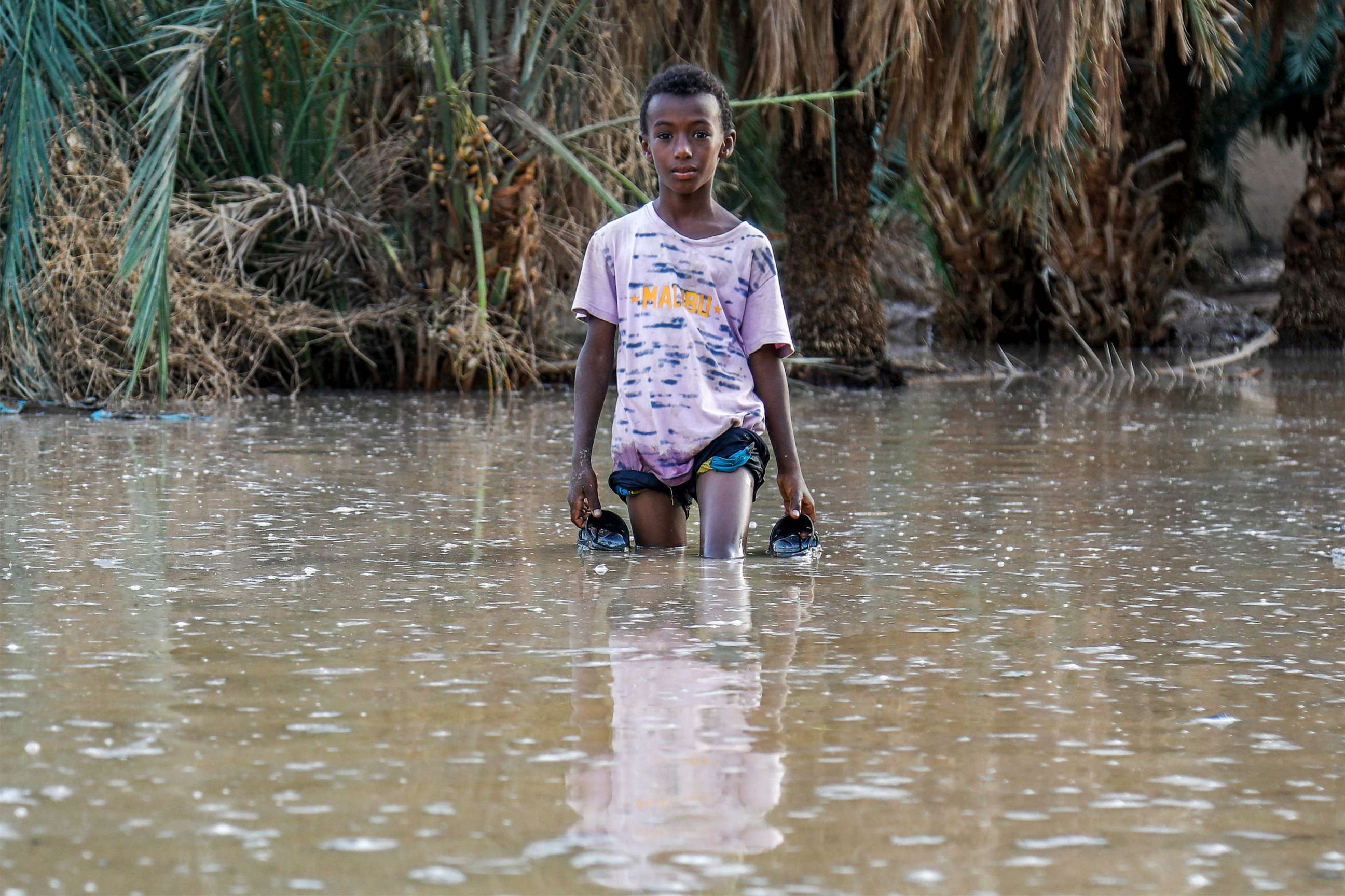 PHOTO: A boy walks through a flooded area in al-Sagai north of Omdurman on August 6, 2023, where torrential rains have destroyed more than 450 homes in Sudan's north.