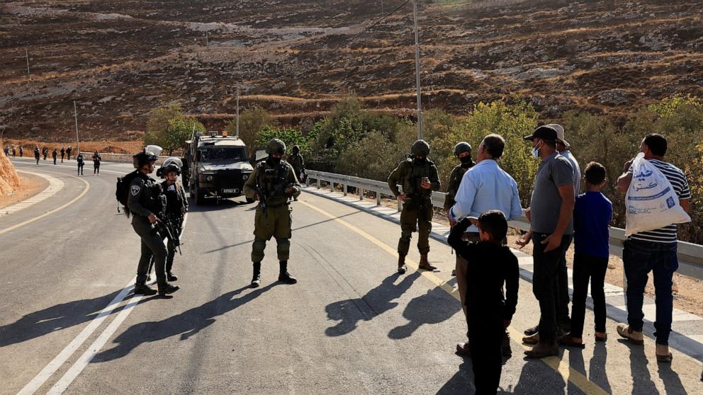 PHOTO: Members of the Israeli forces stand guard as they block the access of Palestinians and foreign activists to olive trees during the olive harvest, near Hebron, in the Israeli-occupied West Bank, October 23, 2025.