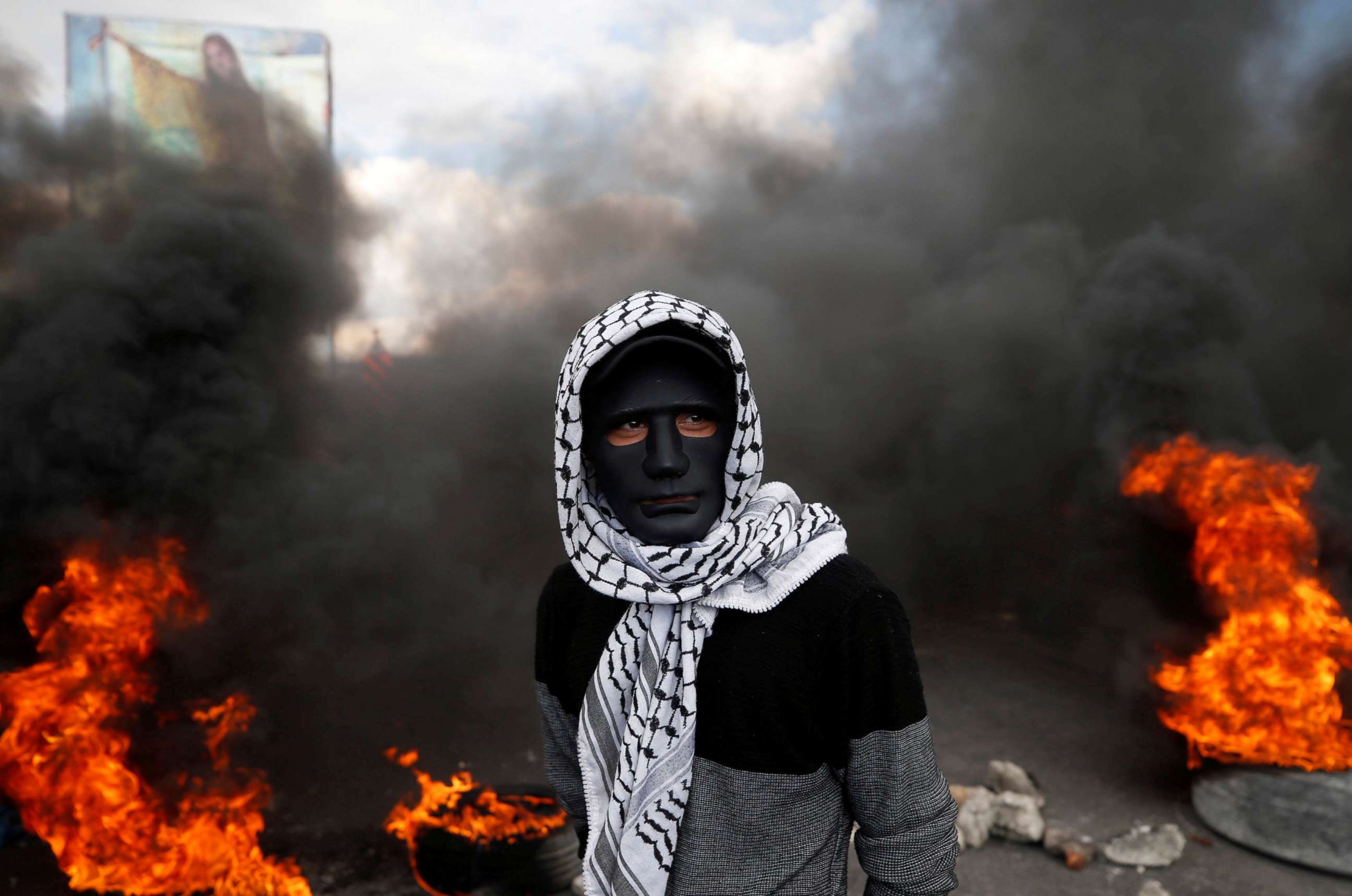 PHOTO: A Palestinian demonstrator stands near burning tires during clashes with Israeli troops at a protest against President Donald Trump's decision to recognize Jerusalem as the capital of Israel, near the West Bank city of Nablus, Dec. 15, 2017. 