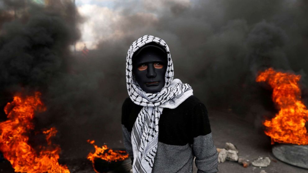 PHOTO: A Palestinian demonstrator stands near burning tires during clashes with Israeli troops at a protest against President Donald Trump's decision to recognize Jerusalem as the capital of Israel, near the West Bank city of Nablus, Dec. 15, 2017. 