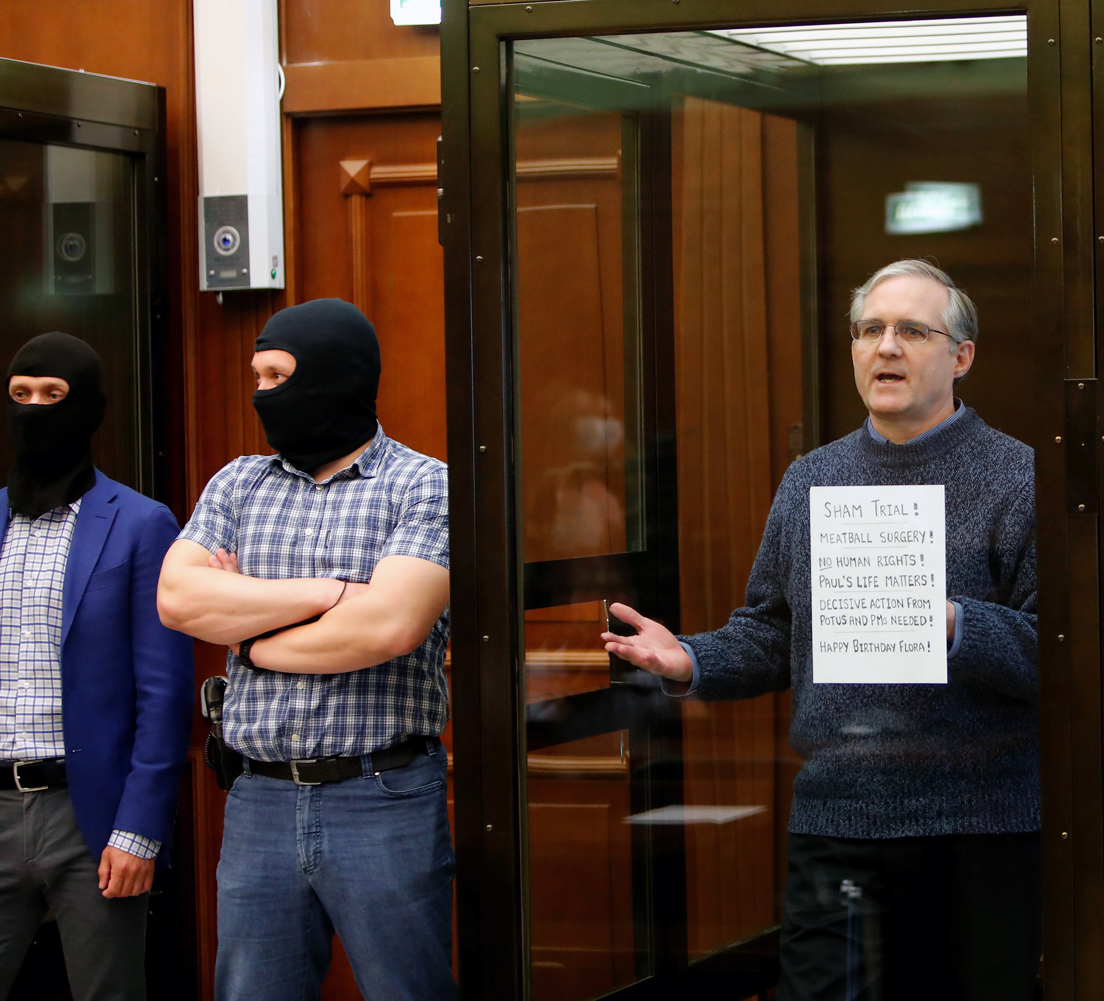 PHOTO: Former U.S. Marine Paul Whelan, who was detained and accused of espionage, holds a sign as he stands inside a defendants' cage during his verdict hearing in Moscow, June 15, 2020.