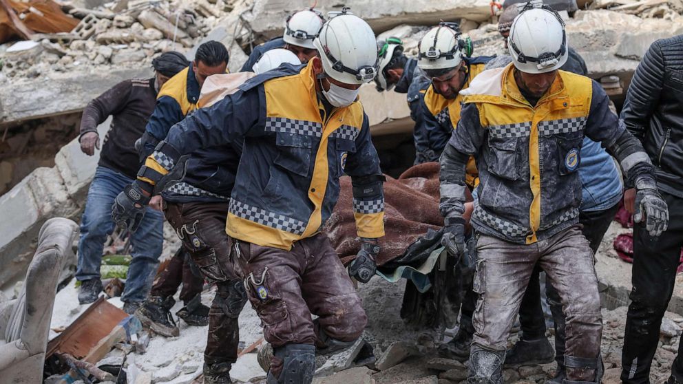 PHOTO: Members of the Syrian civil defence, known as the White Helmets, transport a casualty from the rubble of buildings in the village of Azmarin, Syria, on Feb. 7, 2023.