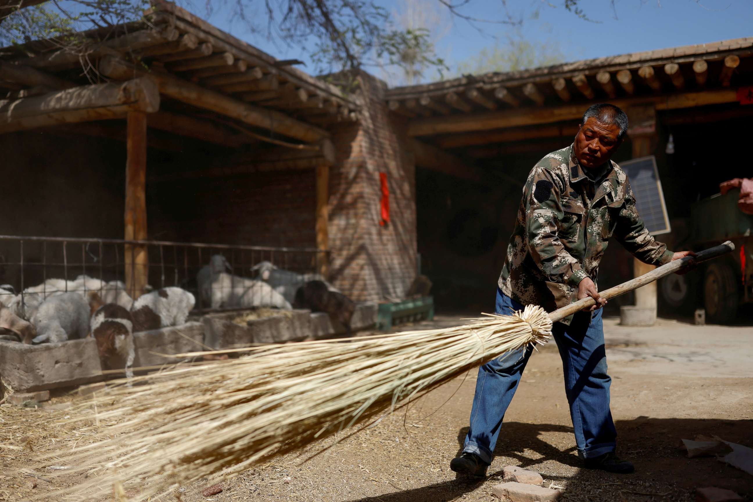PHOTO: Wang Yinji, 53, cleans the backyard of his house in a village near the edge of the Gobi desert, on the outskirts of Wuwei, China, April 14, 2021.