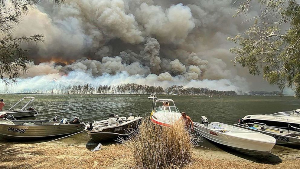 PHOTO: Boats are pulled ashore as smoke and wildfires rage behind Lake Conjola, Australia, Jan. 2, 2020. 