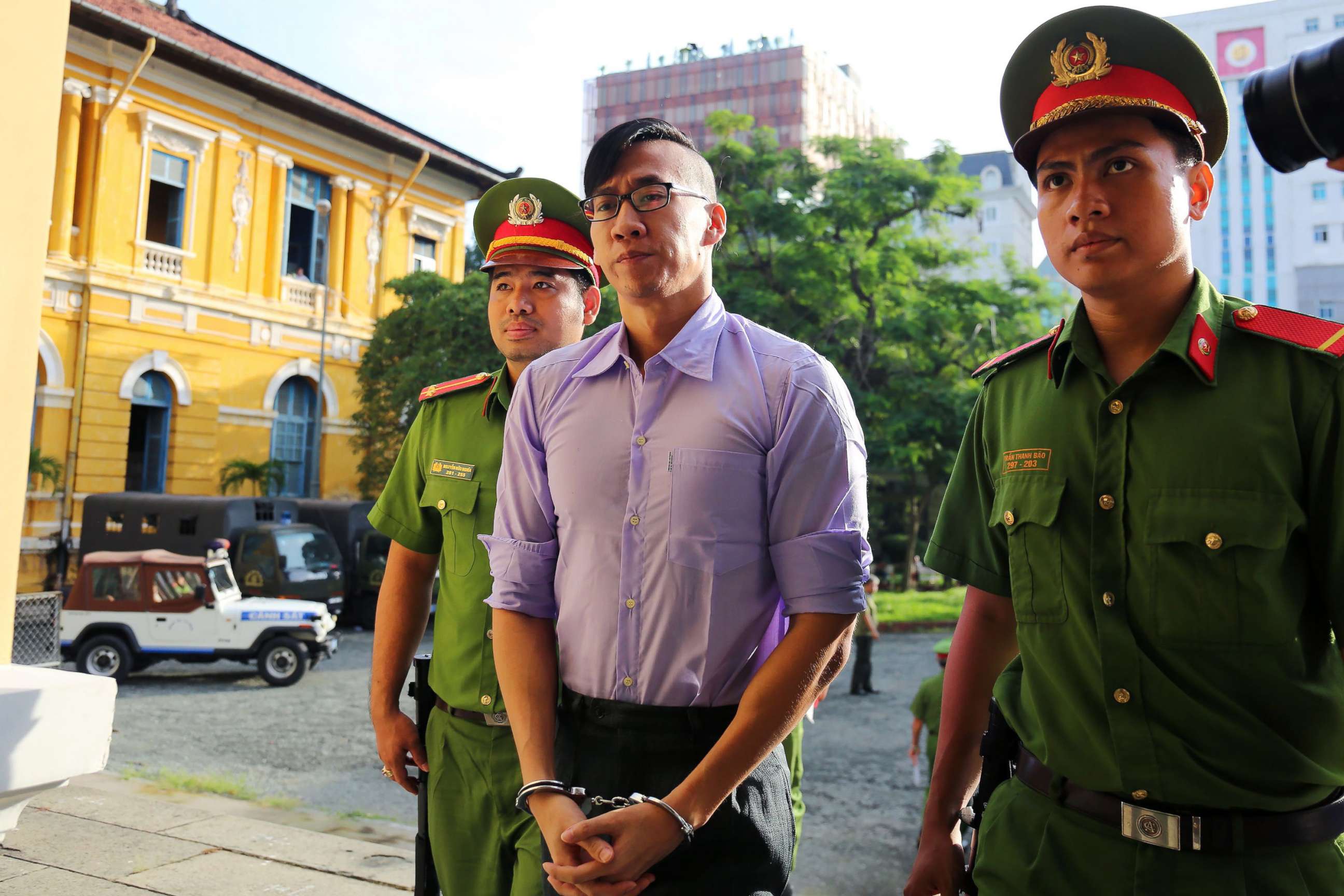 PHOTO: American-Vietnamese citizen William Nguyen (C) is escorted by policemen to a courtroom for his trial in Ho Chi Minh City on July 20, 2018.