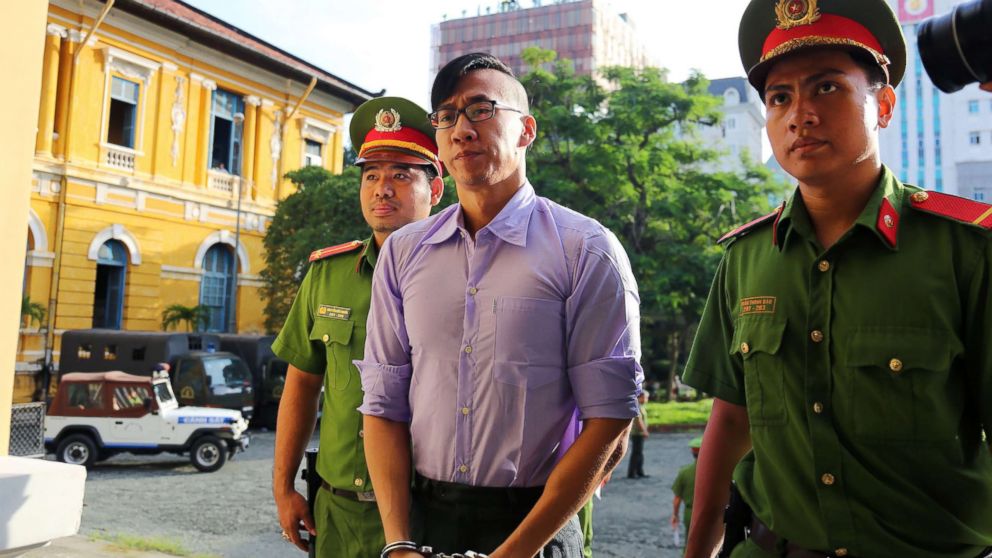 American-Vietnamese citizen William Nguyen (C) is escorted by policemen to a courtroom for his trial in Ho Chi Minh City on July 20, 2018.