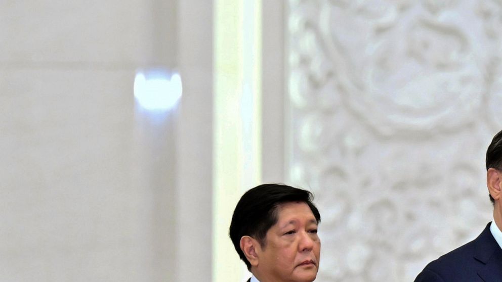 In this photo provided by the Malacanang Presidential Photographers Division, Philippine President Ferdinand Marcos Jr., left, shakes hands with China's National People's Congress (NPC) Standing Committee Chairman Li Zhanshu in Beijing Wednesday, Jan