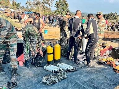 Indian army divers retrieve the body of one of at least 9 miners trapped in a flooded coal mine