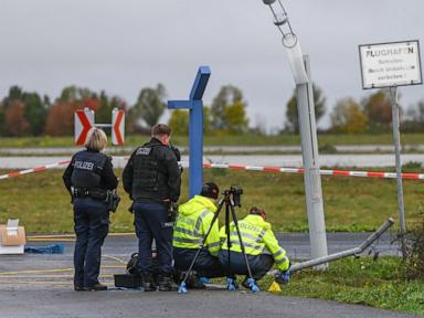 German police say 2 men turned themselves in after smashing car into an airport fence