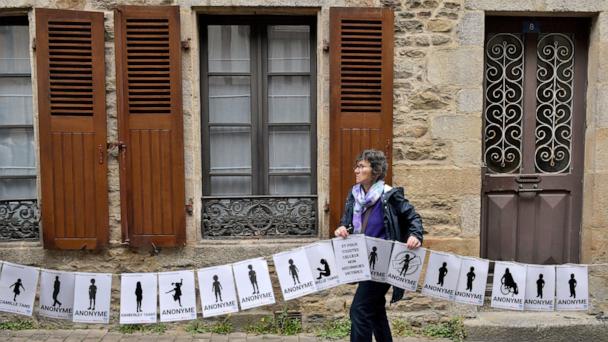 A woman holds a banner representing anonymous victims during a demonstration ahead of the verdict in the trial of Joel Le Scouarnec, a 74-year-old former surgeon, accused of raping and sexually assaulting 299 children, Wednesday, May 28, 2025 in Vannes, Brittany, western France. (AP Photo/Mathieu Pattier)