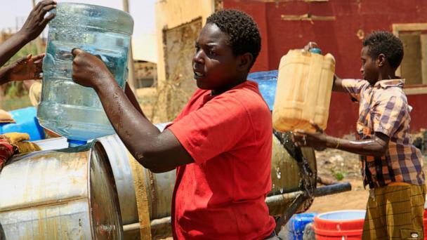 People fill a container by water due to water outages in Khartoum, Sudan, Sunday, May 25, 2025. (AP Photo)