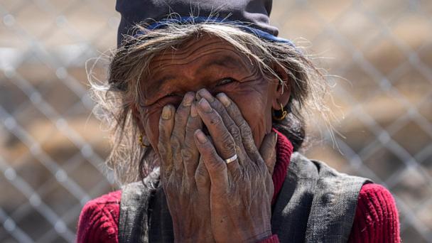An elderly woman reacts while being photographed at the newly relocated settlement of the abandoned Samjungvillage in the Mustang region, 462 kilometers (288 miles) west of Kathmandu, Nepal, Friday, April 18, 2025. (AP Photo/Niranjan Shrestha)