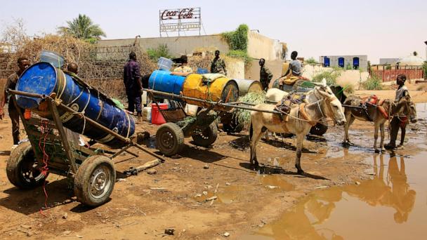 People fill water containers at a distribution point due to water outages in Khartoum, Sudan, Sunday, May 25, 2025. (AP Photo)