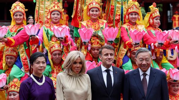 Vietnam's Communist Party General Secretary To Lam and his wife, Ngo Phong Ly, with French President Emmanuel Macron, center right, and his wife Brigitte Macron, center left, pose for a photo with traditional dance performers during a luncheon at Van Mieu, in Hanoi, Vietnam, Monday May 26, 2025. (Chalinee Thirasupa/Pool via AP)