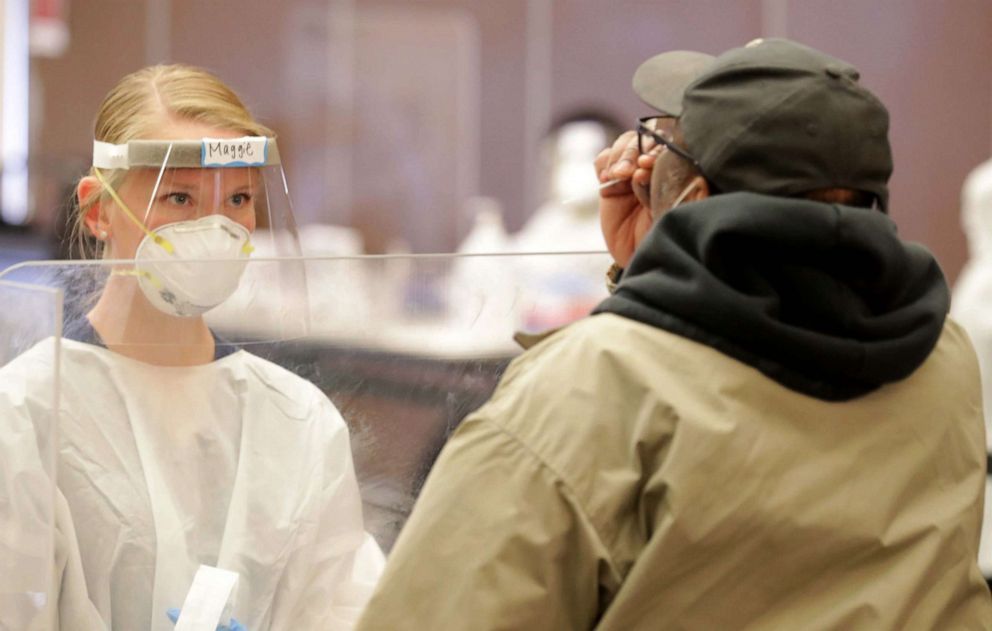 PHOTO: Maggie Fuhrman, a physician assistant, watches as a man takes a rapid-result COVID-19 test at the UW-Milwaukee Student Union on Nov. 16, 2020.