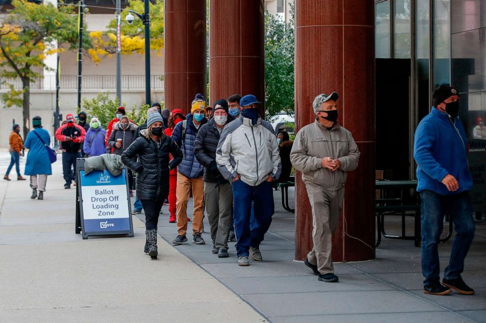 PHOTO: People wait in line to cast their ballots outside Frank P. Zeidler Municipal Building on the first day of in-person early voting for the Nov. 3, 2020 elections in Milwaukee, Wis., on Oct. 20, 2020.