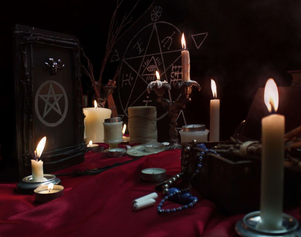 PHOTO: Burning candles, a magic book, quill, jewelry, chalk and pentagram symbol are pictured in this undated stock photo.