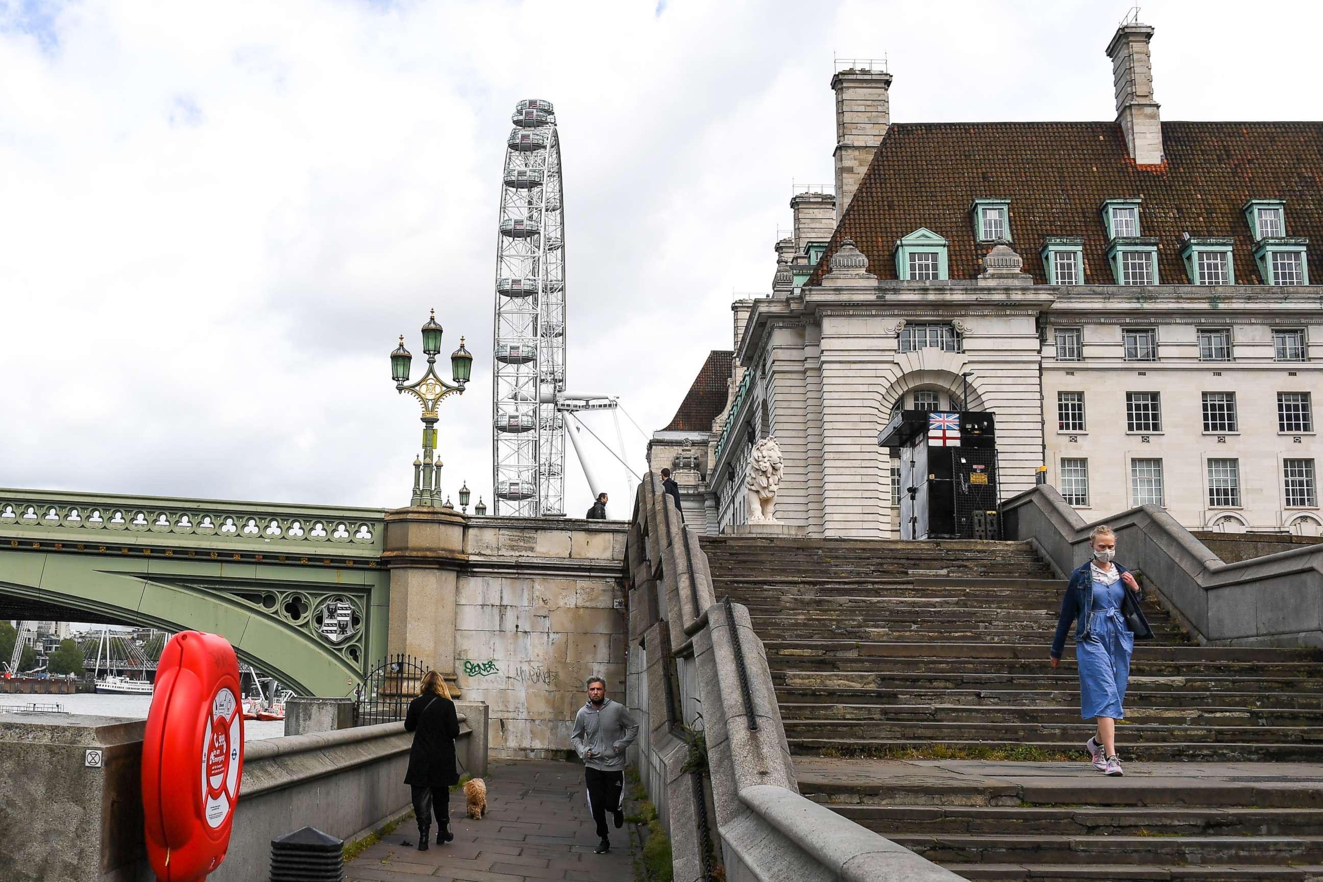 PHOTO: A woman wearing a face mask walks down the stairs at the end of Westminster Bridge in London on May 1, 2020, as the United Kingdom continues its lockdown to curb the spread of the novel coronavirus.