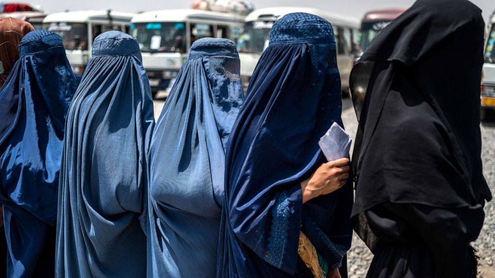 PHOTO: Afghan internally displaced refugee women stand in a queue to identify themselves and receive money as they return home to the east, at the United Nations High Commissioner for Refugees (UNHCR) camp in the outskirts of Kabul on July 28, 2022.