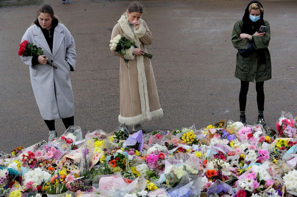 PHOTO: People look at the floral tributes at the bandstand on Clapham Common, London, Monday March 15, 2021. On Saturday hundreds of people disregarded a judge's ruling and police requests by gathering at Clapham Common in honor of Sarah Everard.