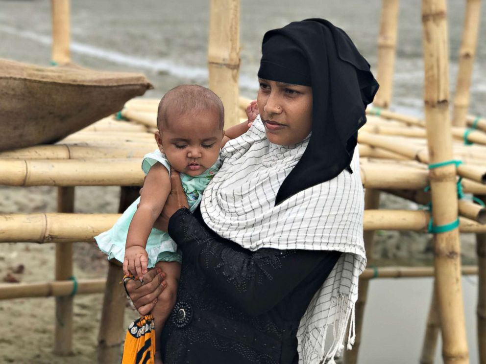 PHOTO: A Rohingya woman and her baby arrive at Shah Porir Dwip Island in Bangladesh, Oct. 2017. Once, refugees arrive, they must wait to be processed and then must make their way to the camps, which are several miles away.