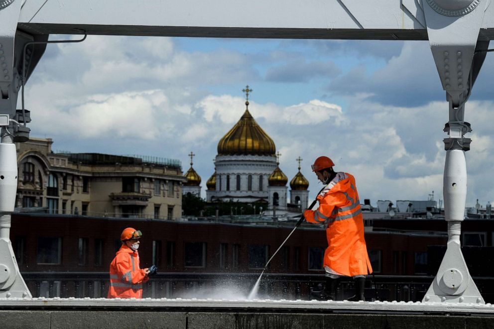 PHOTO: Municipal workers wearing face masks clean Krymsky Bridge across the Moskva river, with the Cathedral of Christ the Saviour seen in the background, in downtown Moscow, Russia, on May 20, 2020, amid the coronavirus pandemic.