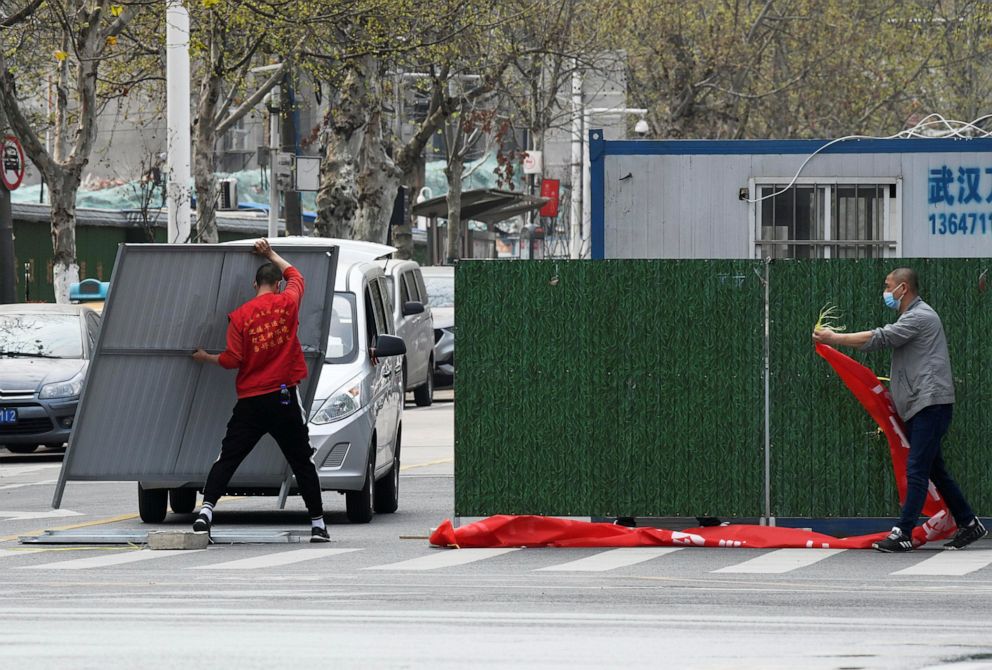 PHOTO: Workers wearing face masks remove barriers on a street in Wuhan, the epicenter of the novel coronavirus outbreak, as the city has started to loosen its lockdown, in Hubei province, China, on March 21, 2020.