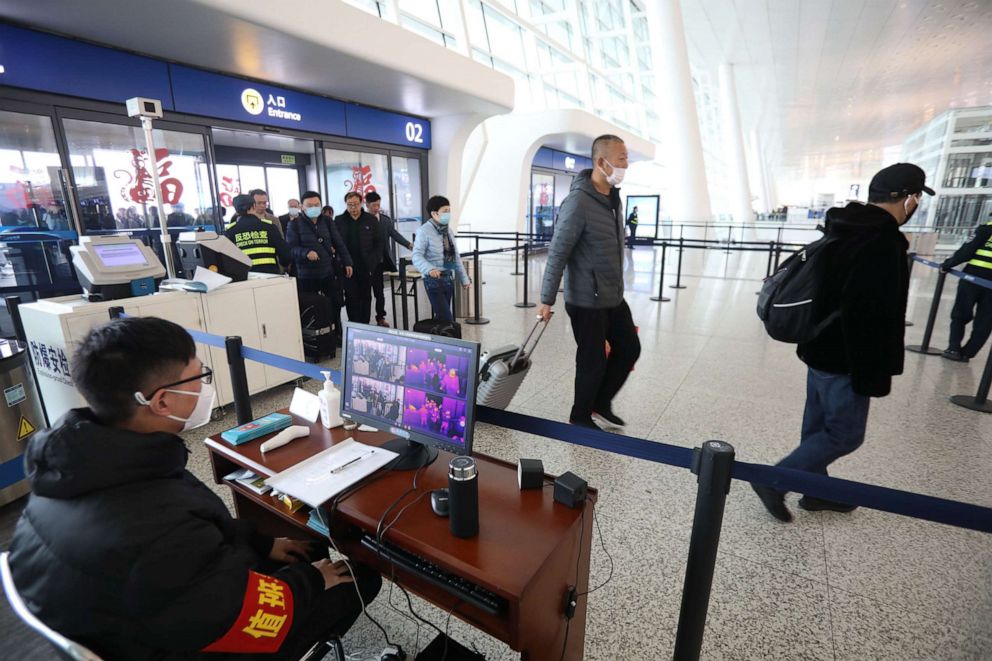 PHOTO: Staff members take passengers' body temperature at Tianhe International Airport in Wuhan, capital of central China's Hubei Province, Jan. 21, 2020. 