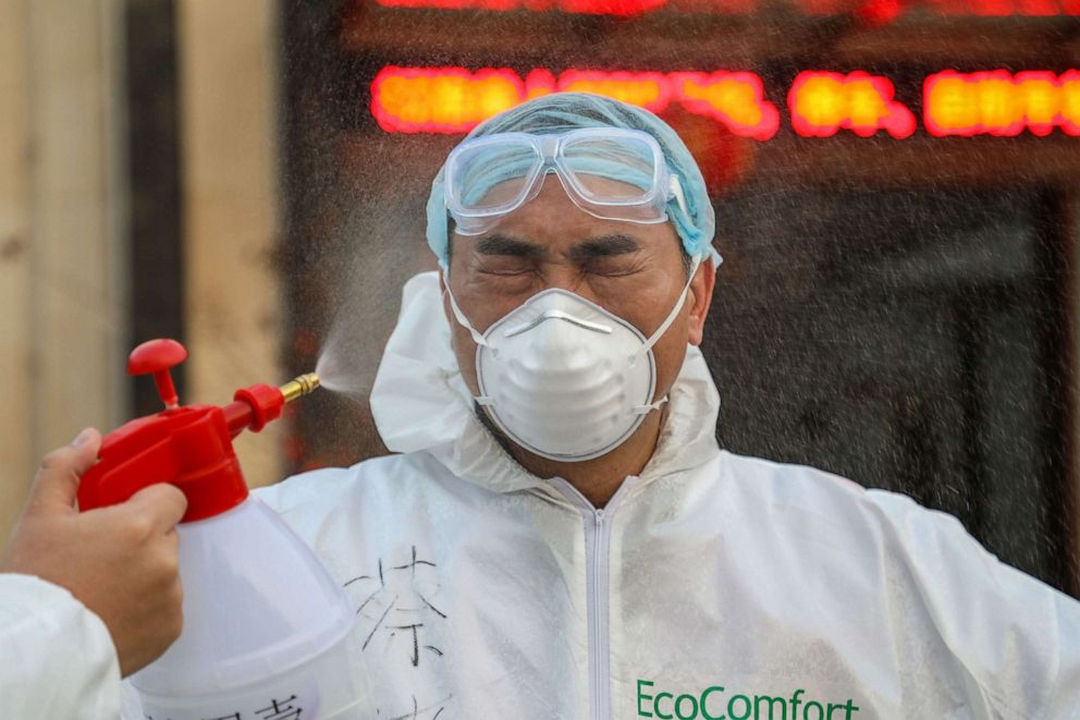 PHOTO: This photo taken on Feb. 3, 2020, shows a doctor being disinfected by his colleague at a quarantine zone in Wuhan, the epicenter of the new coronavirus outbreak, in China's central Hubei province.