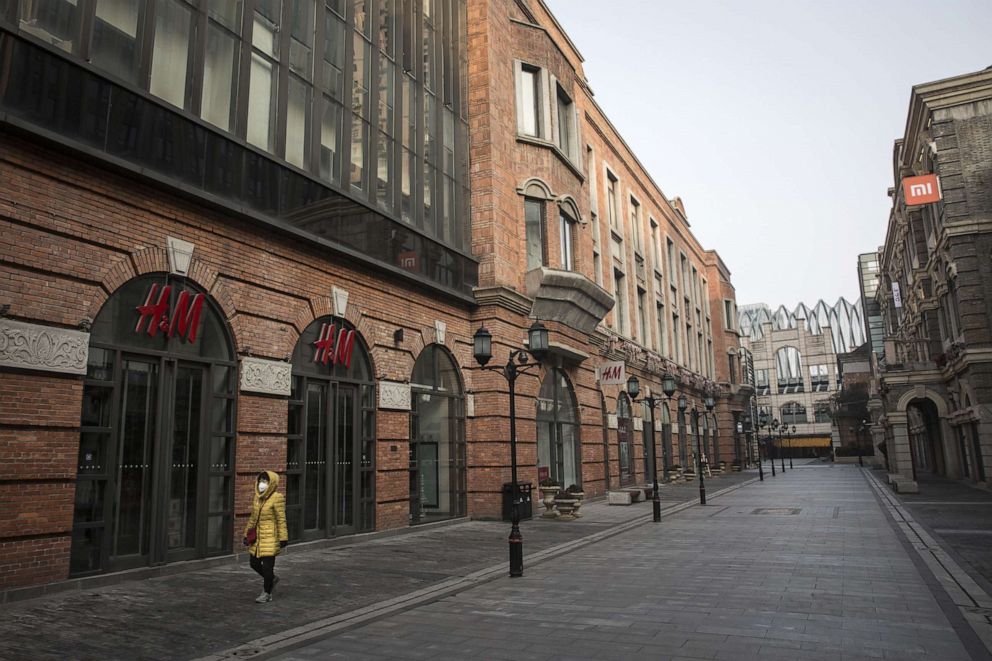 PHOTO: A person wears a protective mask while walking down an empty street in Wuhan, Hubei province, China, Feb.3, 2020.