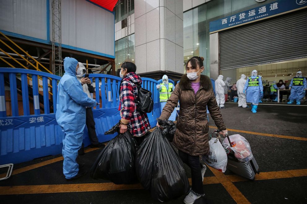 PHOTO: Patients who have recovered from the novel coronavirus leave a temporary hospital set up to treat people infected with the virus in Wuhan in China's central Hubei province on March 9, 2020.
