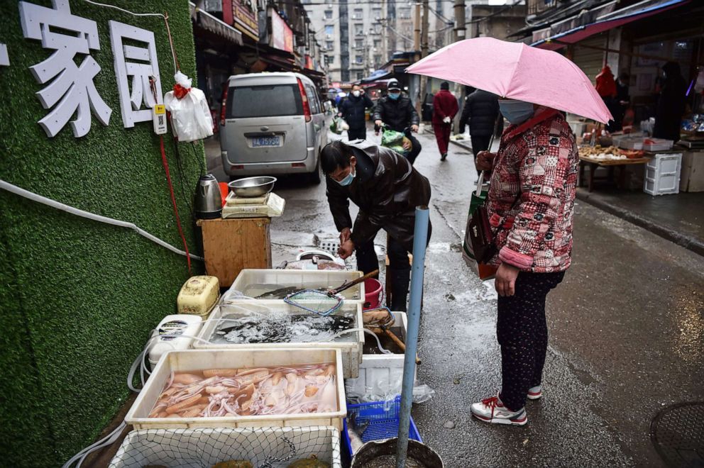 PHOTO: In this Jan. 24, 2020, file photo, a masked vendor sells fish and turtles at a market in Wuhan, China, where the coronavirus was discovered.