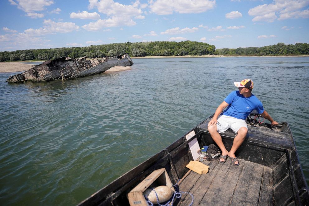 PHOTO: Local fisherman Ivica Skodric, sails his boat past the wreckage of a World War II German warship in the Danube in Prahovo, Serbia, Aug. 18, 2022.