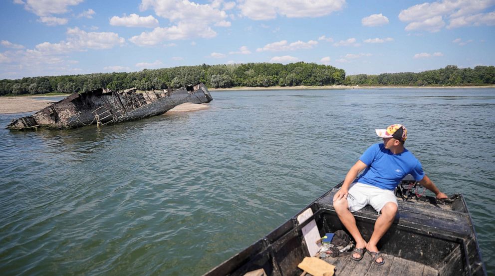 PHOTO: Local fisherman Ivica Skodric, sails on his boat past the wreckage of a World War II German warship in the Danube in Prahovo, Serbia August 18, 2022.