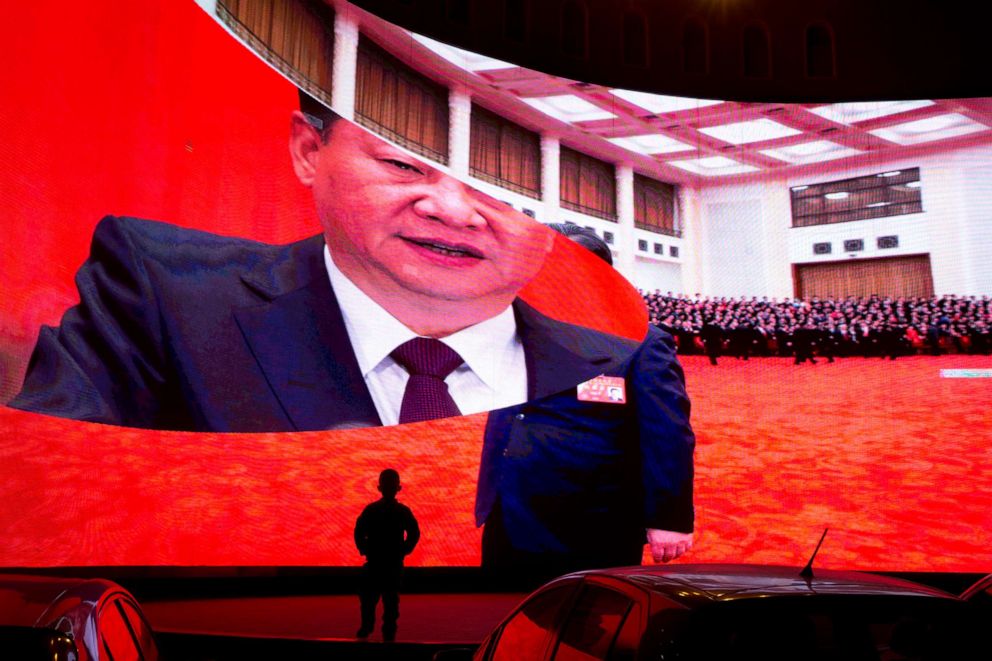 FOTO: Un niño parado cerca de una pantalla grande que muestra imágenes del presidente chino, Xi Jinping, cerca de un estacionamiento en Kashgar, región de Xinjiang, en el oeste de China, el 3 de diciembre de 2018.