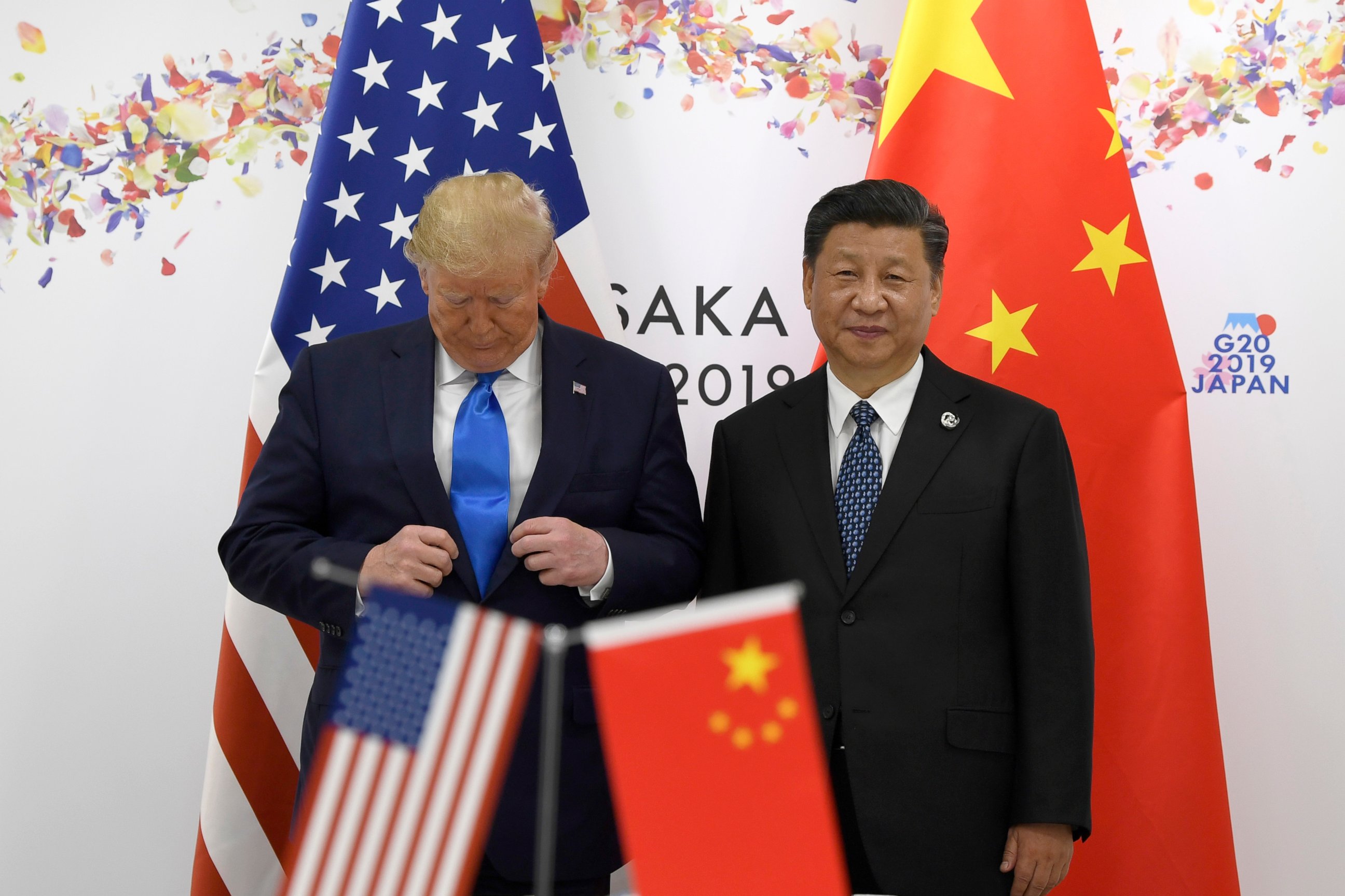 PHOTO: President Donald Trump adjusts his jacket as he poses for a photo with Chinese President Xi Jinping during a meeting on the sidelines of the G-20 summit in Osaka, Japan, Saturday, June 29, 2019. 