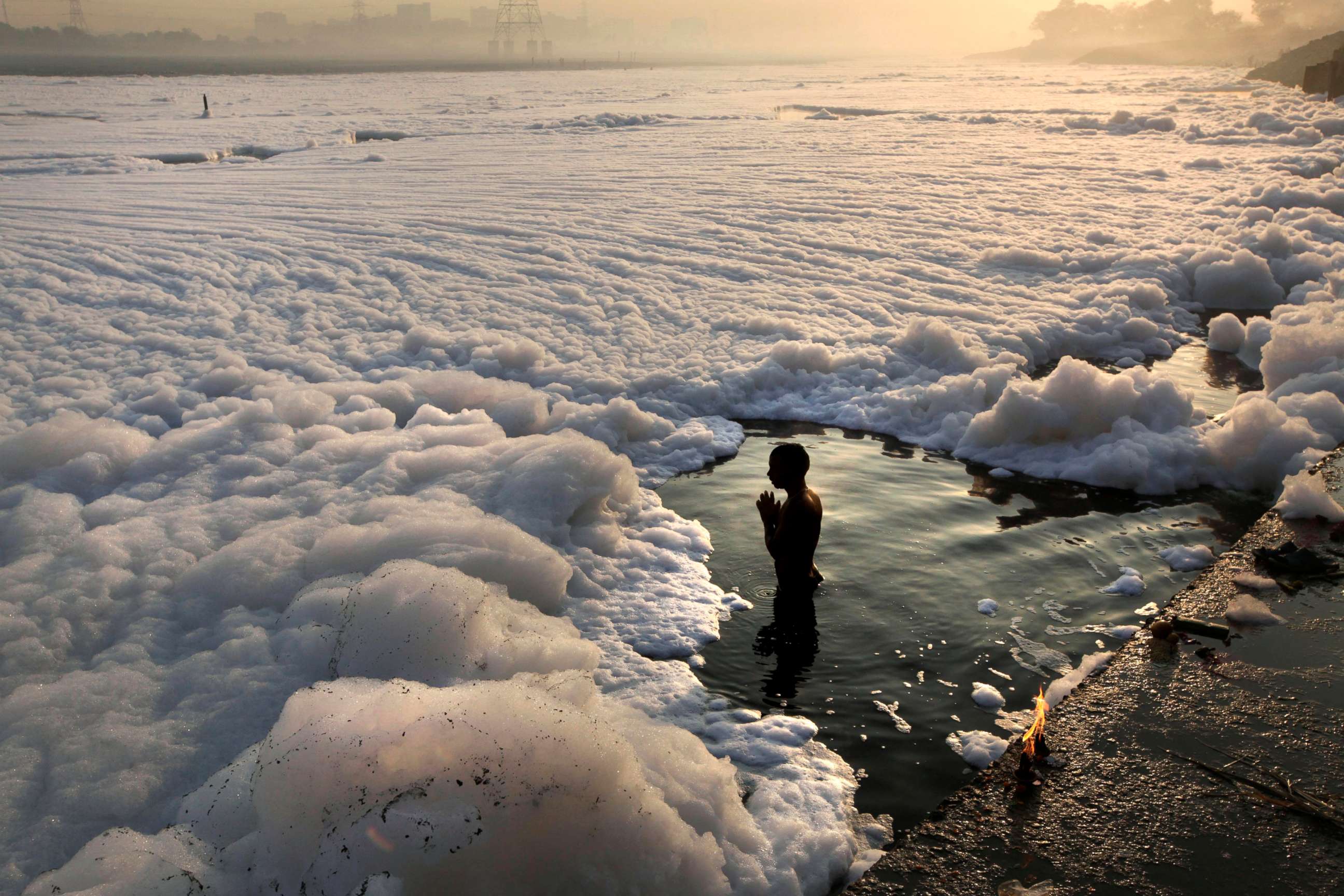 PHOTO: A Hindu devotee offers prayers after a dip in the Yamuna River, surrounded by industrial effluent, during Kartik Purnima festival in New Delhi, Nov. 28, 2012. 