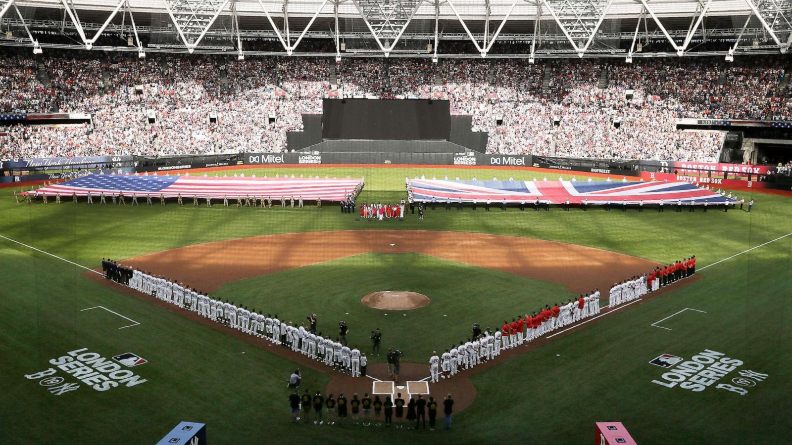 PHOTO: Boston Red Sox and New York Yankees players line up as flags are unfurled before a baseball game, June 29, 2019, in London as Major League Baseball made its European debut at London Stadium.