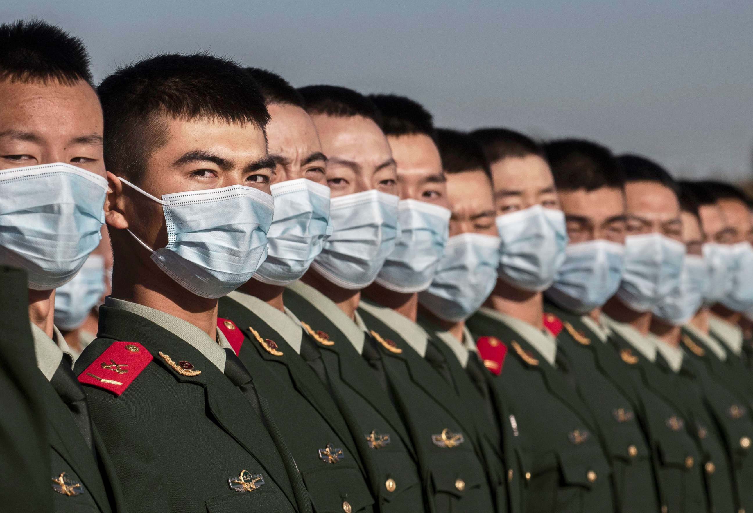 PHOTO: Chinese soldiers from the People's Liberation Army wear protective masks as they line-up after a ceremony marking the 70th anniversary of China's entry into the Korean War, on Oct. 23, 2020 in Tiananmen Square in Beijing. 