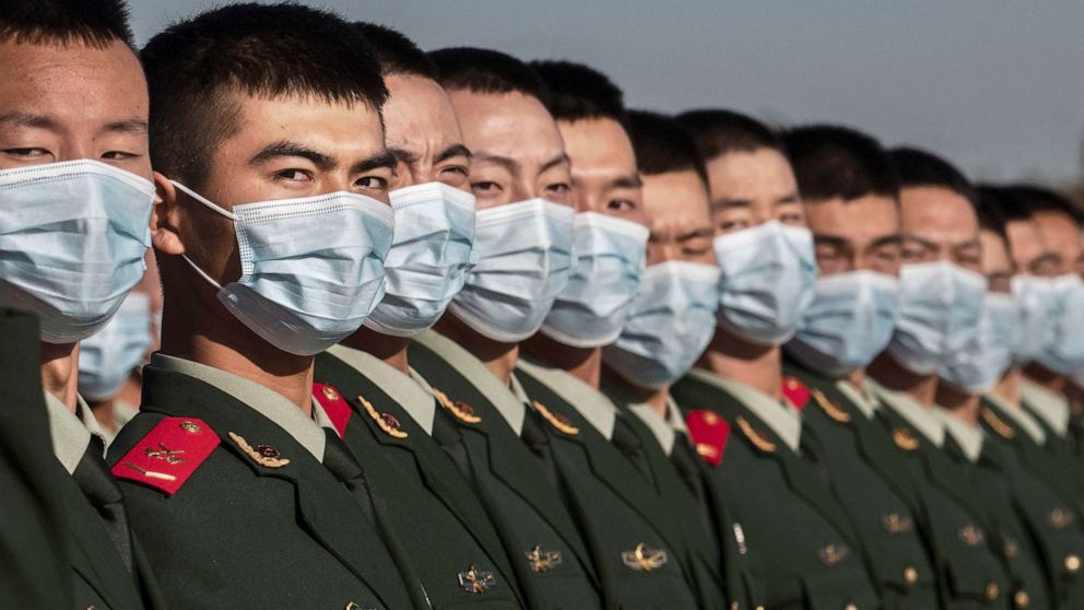 PHOTO: Chinese soldiers from the People's Liberation Army wear protective masks as they line-up after a ceremony marking the 70th anniversary of China's entry into the Korean War, on Oct. 23, 2020 in Tiananmen Square in Beijing. 