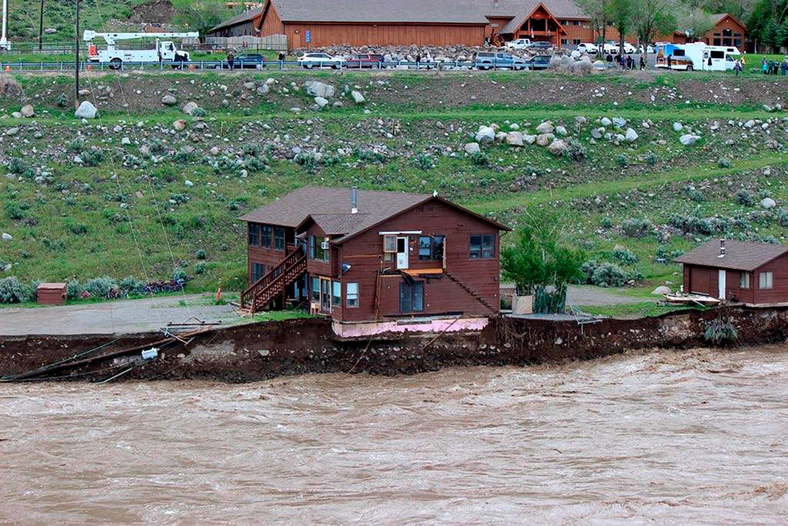 PHOTO: The flooding Yellowstone River undercuts the river bank, threatening a house and a garage in Gardiner, Mont., June 13, 2022.