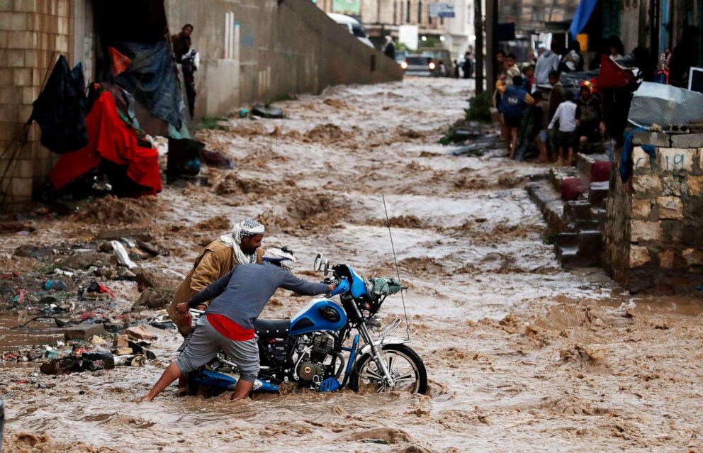 PHOTO: Yemenis attempt to get a motorcycle out of floodwater caused by heavy rainfall in Sana'a, Yemen, July 29, 2020. 