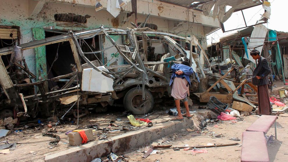 PHOTO: Yemenis gather next to the destroyed bus at the site of a Saudi-led coalition air strike, that targeted the Dahyan market the previous day in the Huthi rebels' stronghold province of Saada, Aug. 10, 2018.