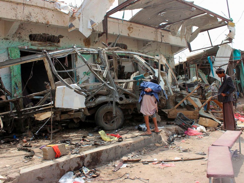 PHOTO: Yemenis gather next to the destroyed bus at the site of a Saudi-led coalition air strike, that targeted the Dahyan market the previous day in the Huthi rebels stronghold province of Saada, Aug. 10, 2018.
