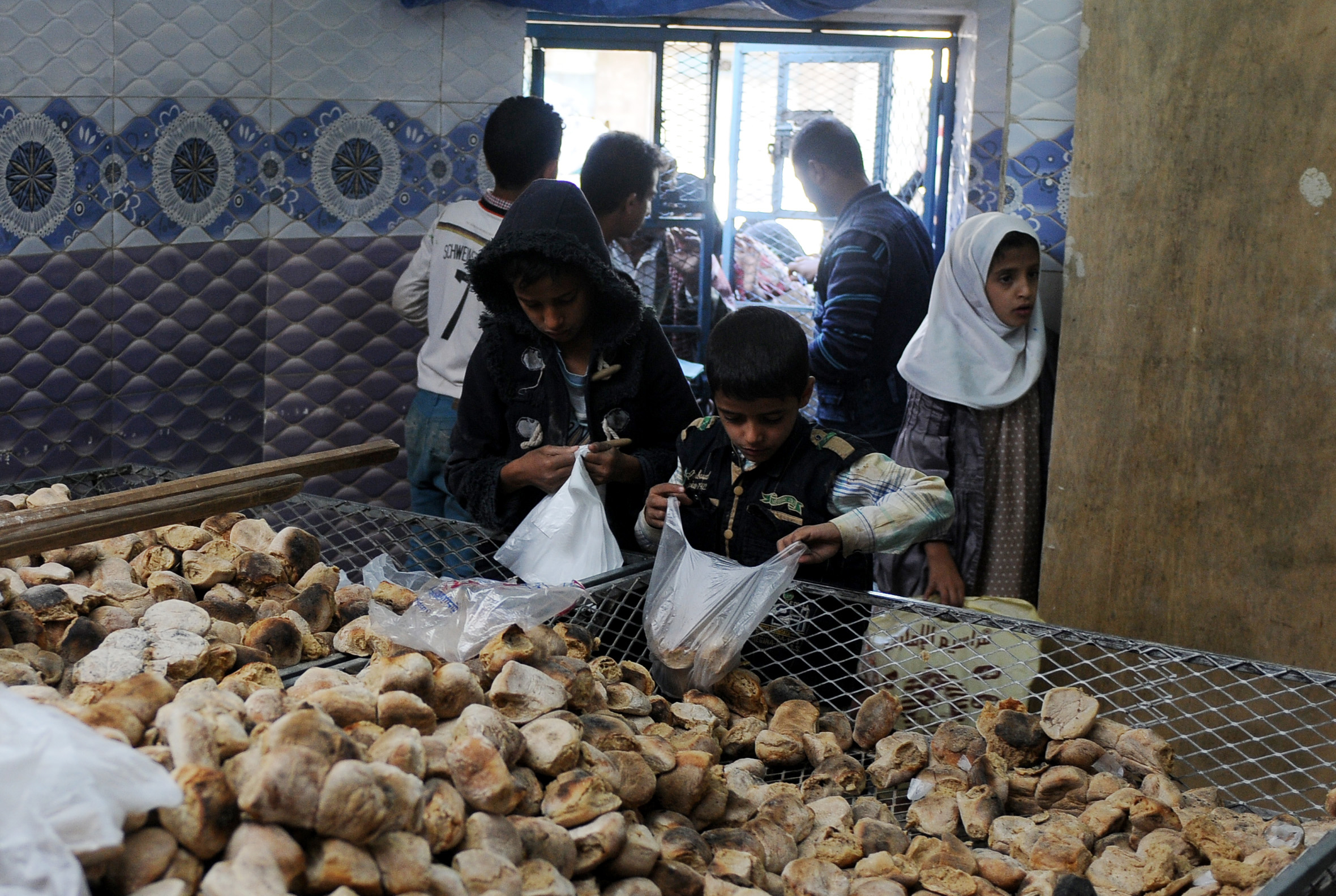 PHOTO: Children distribute free bread to people at a center financed by rich people and merchants in Sana'a, Yemen, Nov. 12, 2017. 