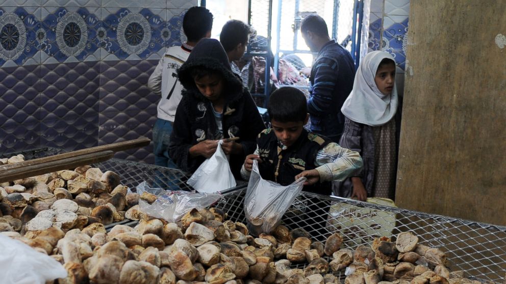 PHOTO: Children distribute free bread to people at a center financed by rich people and merchants in Sana'a, Yemen, Nov. 12, 2017. 